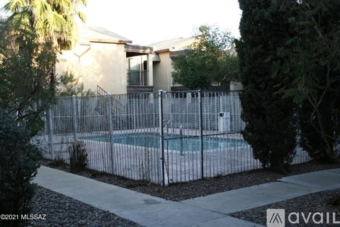 A house with a pool surrounded by a fence.
