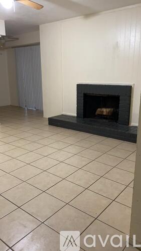 A living room with a fireplace and tiled floor.