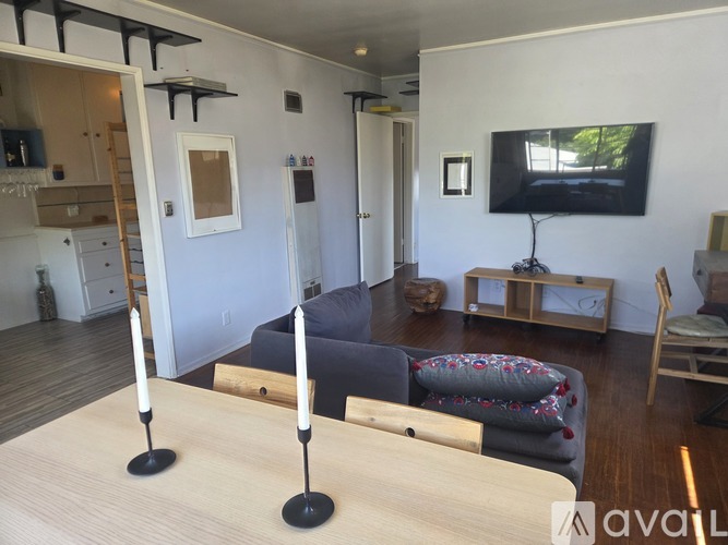 A living room with a grey couch and a television on a stand.