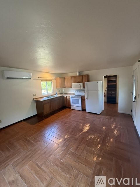 A kitchen with wooden floors and white walls.
