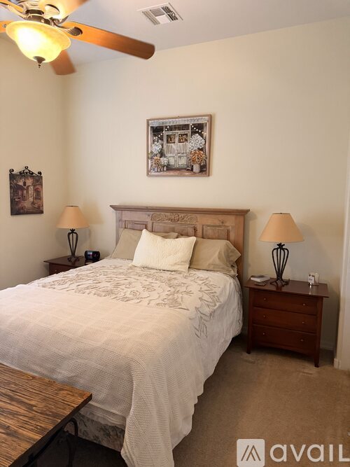 A bedroom with a large bed and a ceiling fan.