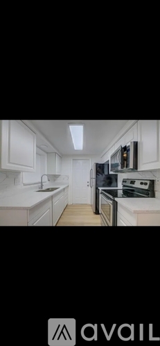 A modern kitchen with white cabinets and appliances.