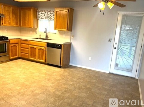 A kitchen with wooden cabinets and a tile floor.