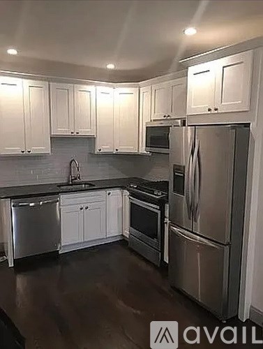 A kitchen with white cabinets and stainless steel appliances.