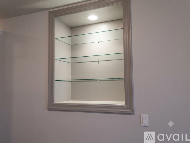 A wall-mounted mirror with four shelves is mounted on a wall.