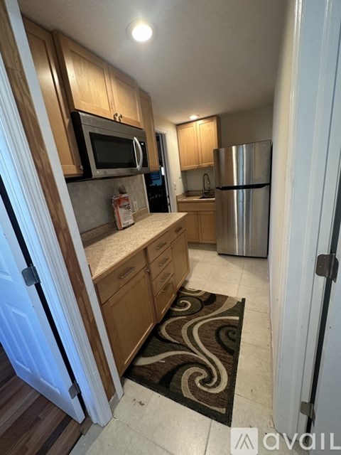 A kitchen with a refrigerator, microwave, and oven.