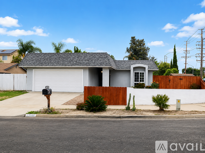 A house with a white garage door and a brown fence.