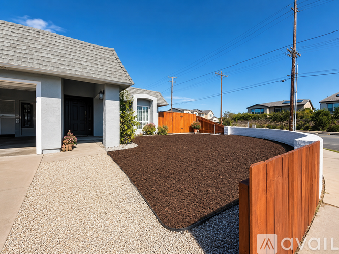 A house with a brown gravel area in front.