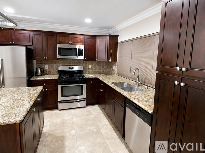 A kitchen with brown cabinets and granite countertops.