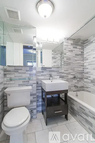 A bathroom with a toilet, sink, and a shower.