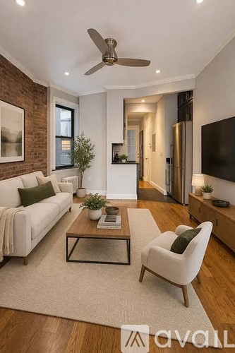 A living room with a white couch, a glass coffee table, and a ceiling fan.