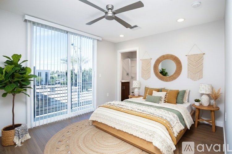 A bedroom with a large bed and a ceiling fan.