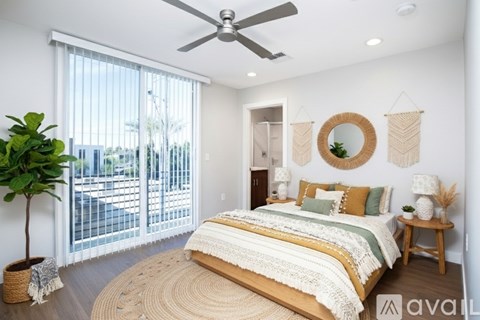 A bedroom with a large bed and a ceiling fan.