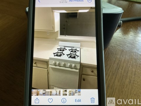 A phone screen displays a photo of a kitchen with a stove top.