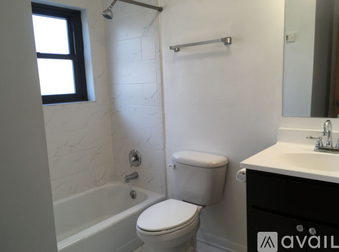 A white toilet sits next to a bathtub in a bathroom.