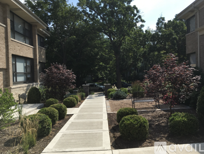A pathway leads through a landscaped area with bushes and trees.