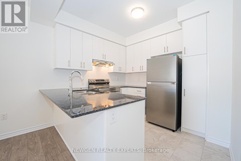 A kitchen with a granite counter top and stainless steel appliances.