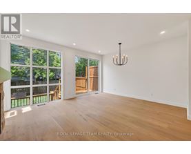 A spacious room with wooden floors and a chandelier.