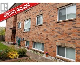 A brick building with the words "Utilities Included" on a red banner.