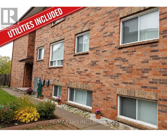 A brick building with the words "Utilities Included" on a red banner.