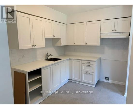 A kitchen with white cabinets and a sink.