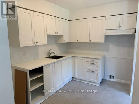 A kitchen with white cabinets and a sink.