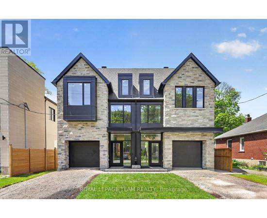 A modern house with a stone facade and large windows is for sale.