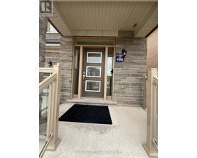 The front door of a house with a glass panel and a sign above it.