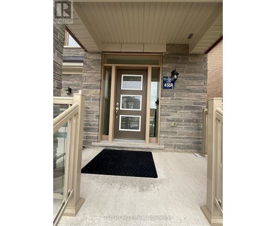 The front door of a house with a glass panel and a sign above it.