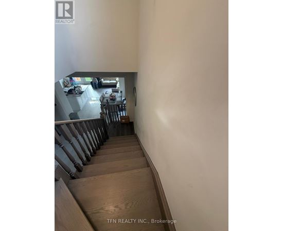 A staircase leading to a living room with a dining table and chairs.