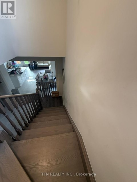 A staircase leading to a living room with a dining table and chairs.