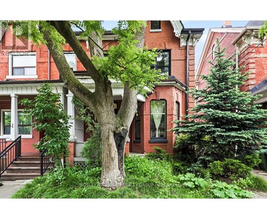 A red brick house with a tree in front.