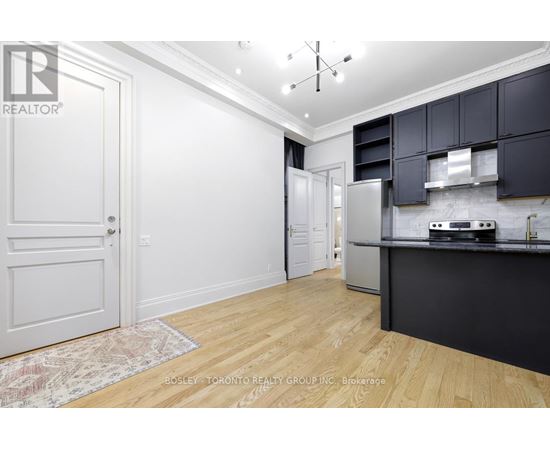 A kitchen with a white door and a rug on the floor.