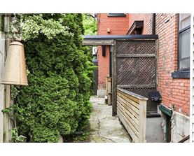 A narrow alley with a gate and a brick building.