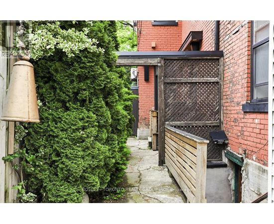 A narrow alley with a gate and a brick building.