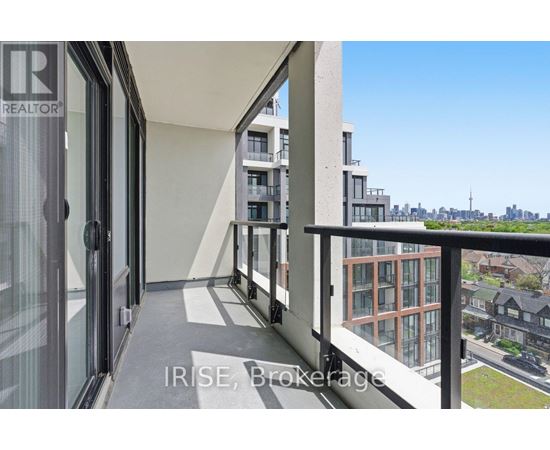 A balcony with a glass door and a view of the city.