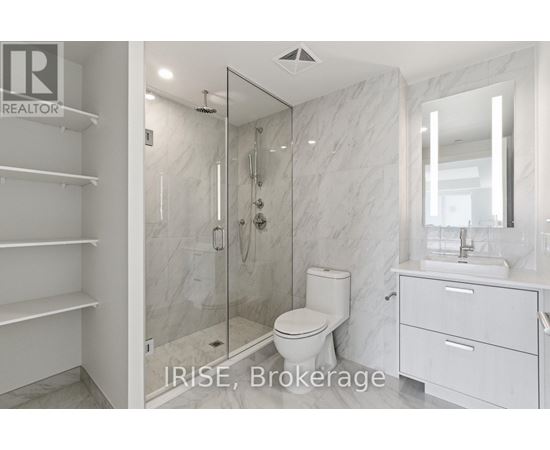 A bathroom with a toilet, sink, and walk-in shower.