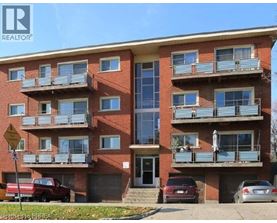 A red brick apartment building with a balcony on the second floor.