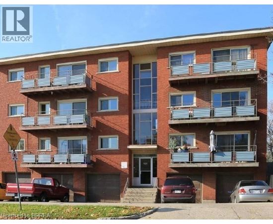 A red brick apartment building with a balcony on the second floor.