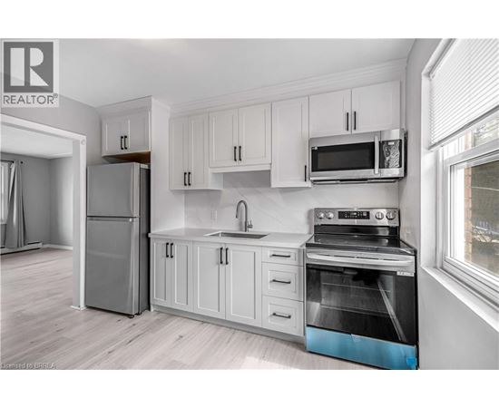 A kitchen with white cabinets and a stainless steel oven.