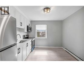 A kitchen with white cabinets and a stainless steel refrigerator.