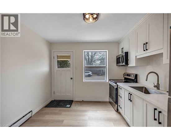 A kitchen with white cabinets and a black stove top oven.