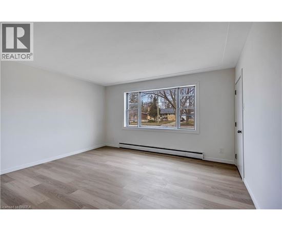 A room with a window and a picture on the wall.