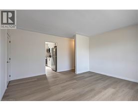 A spacious room with a kitchen area in the background.
