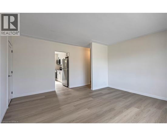 A spacious room with a kitchen area in the background.