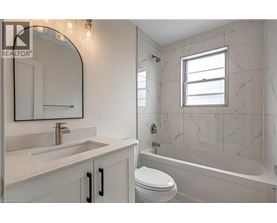 A bathroom with a marble wall and a white toilet.