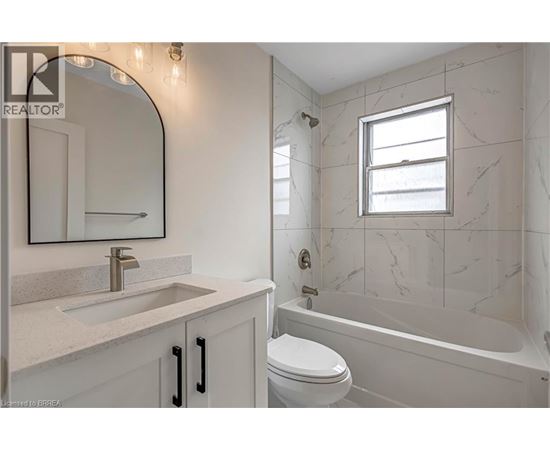 A bathroom with a marble wall and a white toilet.
