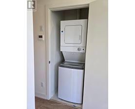 A white dishwasher is in a small alcove in a room.