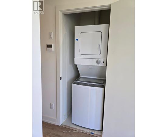 A white dishwasher is in a small alcove in a room.