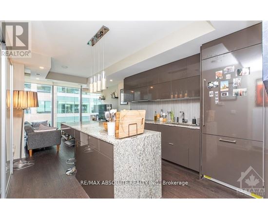 A modern kitchen with a large island and stainless steel appliances.